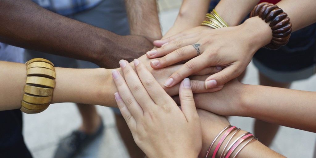 Close-up of human hands stacked upon one another