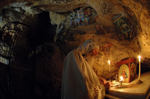Coptic monk praying in original cave of St. Anthony.